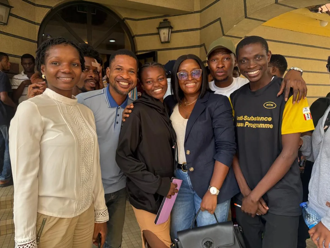 Standing group of masterclass participants inside an arched building