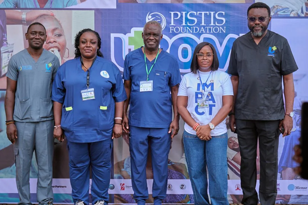 Five people standing together in front of a Pistis Foundation UBOMI banner